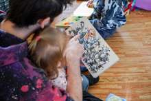 Photo d'un adulte présentant un livre à une jeune enfant.