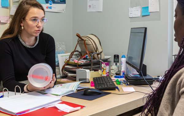 Photo : La responsable de l'Espace Parents-Enfants informe une maman et lui donne une boîte de lait maternisé. Par respect de la vie privée, le visage de la bénéficiaire n'est pas visible.