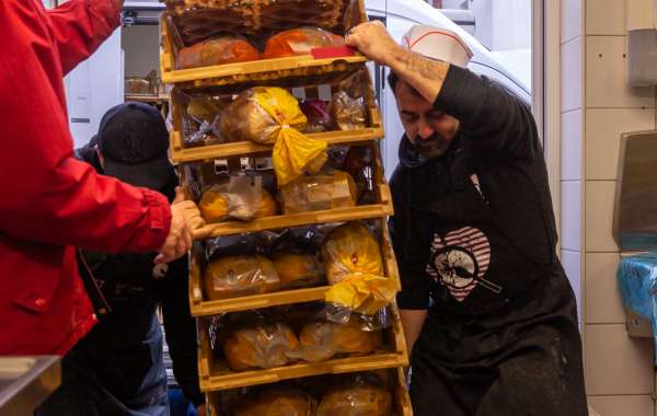 Photo : Les chauffeurs et l'équipe cuisine déchargent les bacs de pain donnés par les boulangeries.