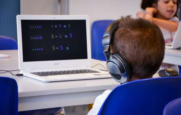 Un enfant travaille sur un ordinateur sur lequel il regarde une vidéo de mathématique venant de la plateforme Khan Academy