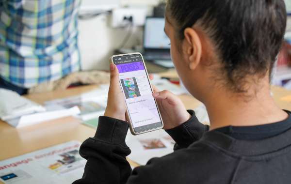 Une jeune fille regarde son téléphone sur lequel elle doit se demander si une information est fausse ou non